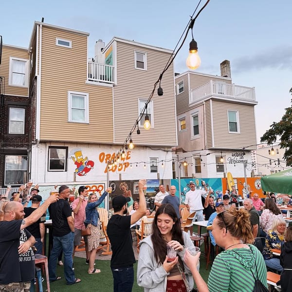 Patrons enjoying drinks and conversation in the outdoor patio of Tennessee Avenue Beer Hall.