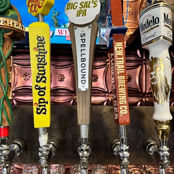 Close-up of five beer taps with various branded handles, including "Sip of Sunshine" and "Modelo."