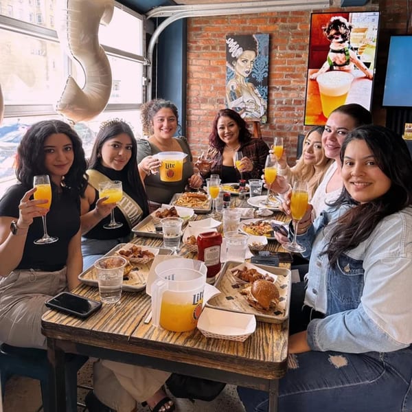 A group of women celebrating a birthday at Tennessee Avenue Beer Hall, enjoying food and drinks.