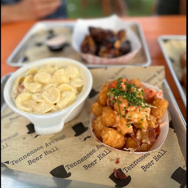 Mac and cheese, loaded tater tots, and chicken wings on a tray from Tennessee Avenue Beer Hall.